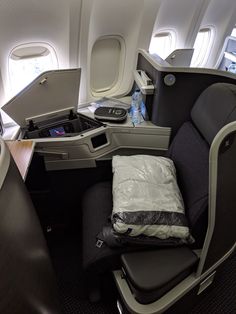 the inside of an airplane with its seat down and luggage on the backrests