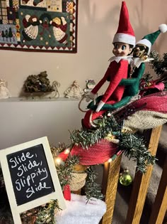 an elf sitting on top of a christmas tree next to a sign that says side - by - side