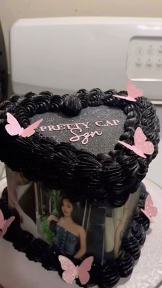 a heart shaped cake with pink butterflies on it and a photo frame in the middle