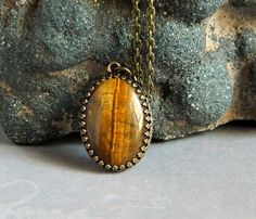 Tiger Eye Pendant Brown Statement Tiger Eye by MsBsDesigns on Etsy Spiritual Bronze Oval Jewelry, Spiritual Oval Bronze Jewelry, Bohemian Bronze Oval Necklace, Brass Cabochon Oval Pendant Jewelry, Brass Oval Pendant With Cabochon, Antique Gold Brass Necklace With Cabochon, Antique Gold Cabochon Brass Necklace, Oval Cabochon Brass Necklace, Oval Cabochon Pendant In Brass