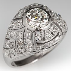 This striking circa 1920's Art Deco era ring features a domed, pierced top with one (1) centered, bezel set, old European cut diamond, bordered with forty-four (44), bead set, single/old European cut diamonds. The ring measures 11.7mm at the top, rises 6.1mm above the finger, tapering to 1.9mm wide and 0.9mm thick at the base of the shank. This ring is currently a size 3.5. Classic Platinum Dome Ring For Anniversary, Art Deco Diamond Ring With Bezel Setting, Classic Platinum Dome Ring, Classic Formal Dome Ring With Center Stone, Classic Dome Ring With Diamond Accents, Classic Dome Ring With Single Cut Diamonds, Vintage Diamond Ring With Bezel Setting And Round Band, Vintage Oval Diamond Dome Ring, Classic Diamond Dome Ring With Prong Setting