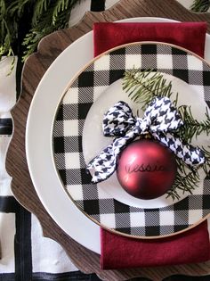 a christmas ornament sitting on top of a plate next to a red napkin