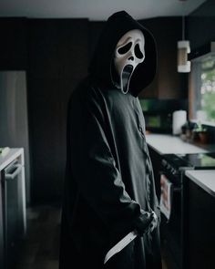 a person wearing a mask and holding a knife in a kitchen with dark wood cabinets