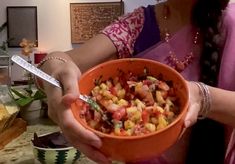 a woman holding a bowl full of food