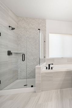 a bathroom with white walls and flooring has a large mirror over the bathtub