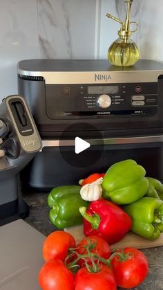 some green and red bell peppers on a cutting board next to an appliance