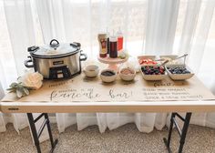 a wooden table topped with bowls of food next to a pot filled with fruit and veggies