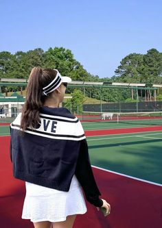 a woman standing on top of a tennis court holding a racquet in her hand