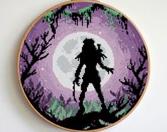 a cross - stitch image of a zombie in front of a full moon with trees