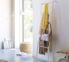 a room with white walls and blue flooring has a ladder leaning against the wall