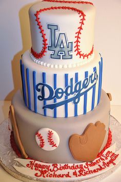 a three tiered cake decorated with baseballs, mitts, and letters that read dodgers