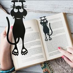 a person holding an open book with a cat cut out of it