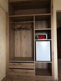 a wooden closet with an ice chest and refrigerator freezer on the bottom shelf next to it