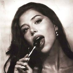 a black and white photo of a woman brushing her teeth