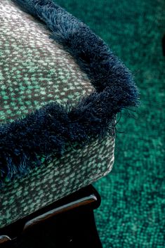 an upholstered chair with blue and green carpet