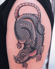 a rat tattoo on the right arm and shoulder, with an arrow in it's tail