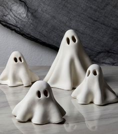 three white ghost figurines sitting on top of a table