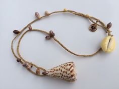 a necklace with shells on it and a shell charm hanging from the end of it