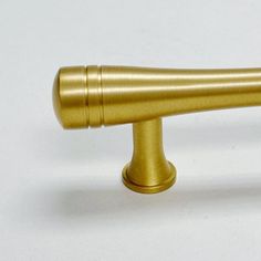 a brass colored handle on a white background