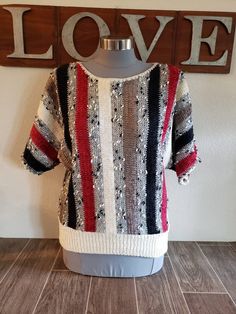 a sweater on a mannequin in front of a love sign