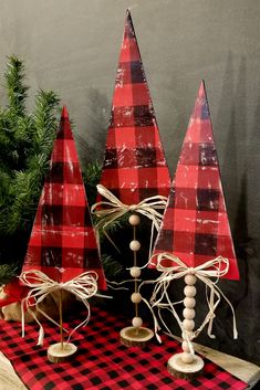 three red and black christmas trees sitting on top of a table