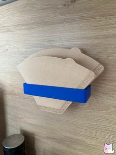 a close up of a blue handle on a wooden door with a paper towel hanging from it