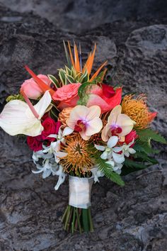 a bouquet of flowers sitting on top of a rock