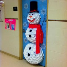 two snowmen made out of toilet paper on the floor in front of a blue door