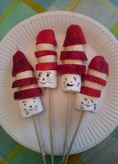 marshmallows and strawberries are arranged on a paper plate