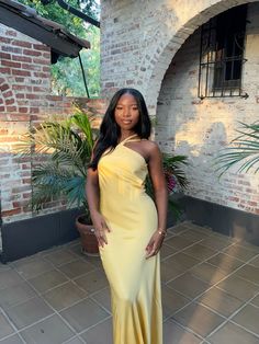 a woman in a yellow dress posing for the camera