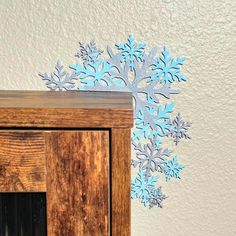 there is a snowflake made out of paper on top of a wooden cabinet