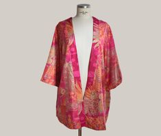 Add a touch of elegance and color to your wardrobe with this beautiful boho style kimono. Made from a lightweight, soft fabric, this kimono is perfect for any occasion, from a casual outing to a special night out. + You have two options, one features a vibrant print in fuchsia, gold and orange tones, with patterns that evoke an ethnic and bohemian style. And the second option in blue tone. + Made from a blend of high-quality fabrics that ensure comfort and durability. + One size (approximately s Bohemian Long Kimono With Vibrant Print, Long Bohemian Kimono With Vibrant Print, Long Kimono With Vibrant Print For Festival, One Size Pink Kimono For Summer, Pink Boho Print Kimono For Beach, One Size Floral Print Kimono For Festivals, Bohemian Patterned Kimono With Vibrant Print, Pink Bohemian Summer Kimono, One-size Kimono For Festival