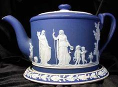 a blue and white tea pot with figures on it