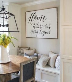 a dining room table with chairs and a bench in front of it that has a sign on the wall above it