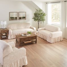 a living room with two couches and a coffee table in front of a window