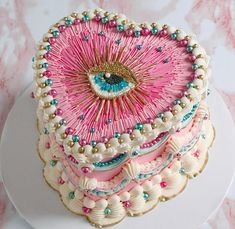 a pink and white cake with an eye on it