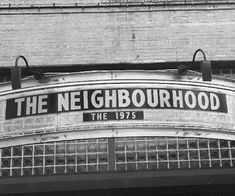 black and white photograph of the neighborhood sign on an old building in new york city