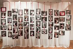 a group of pictures hanging on the wall next to each other in front of a white curtain