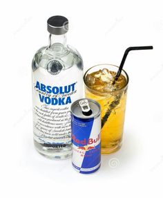 an alcoholic drink next to a can of absolut vodka with a straw in it