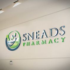 the logo for sneads pharmacy is displayed on a wall in an office building