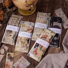 several maps are laid out on a table next to a globe and other items that have been placed around it