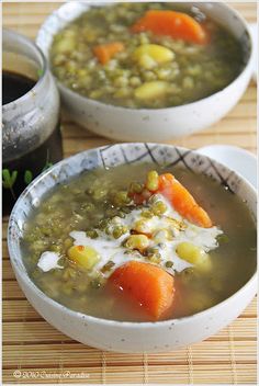 two bowls of soup with carrots and peas