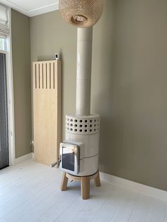 a stove sitting on top of a wooden stand in a living room next to a radiator