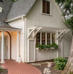 a white house with a brick walkway leading to the front door