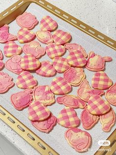 pink and yellow heart shaped cookies are on a baking sheet, ready to go into the oven