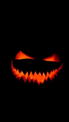 a scary pumpkin with glowing eyes in the dark