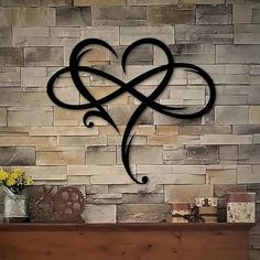 a fireplace with a heart shaped iron decoration on it's mantle next to a brick wall