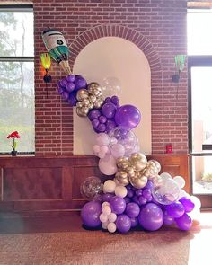 balloons are stacked on top of each other in front of a brick wall and window