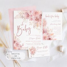 pink flowers and greenery are on top of the baby's birth announcement cards