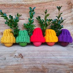 the crocheted mushrooms are lined up next to each other, with plants growing out of them